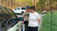 Woman in handcuffs being arrested by a police officer.