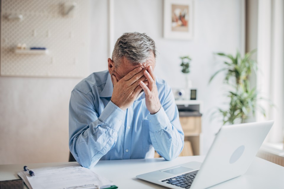Worried senior manager sitting at his desk.