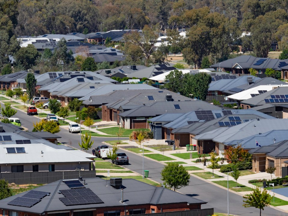Aerial view of a suburban neighborhood with houses equipped with solar panels.