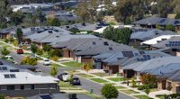 Aerial view of a suburban neighborhood with houses equipped with solar panels.