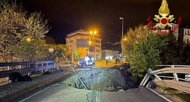 Large sinkhole in road at night.