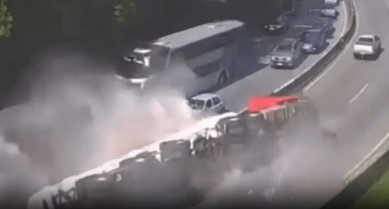 Multi-vehicle accident on highway with large cloud of dust or smoke.