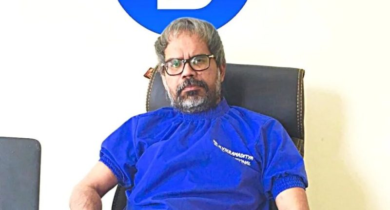 Dr. Narendra Vikramaditya Yadav sitting at his desk.