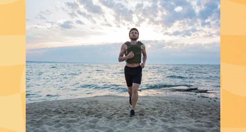 athlete training with a weighted vest on the beach