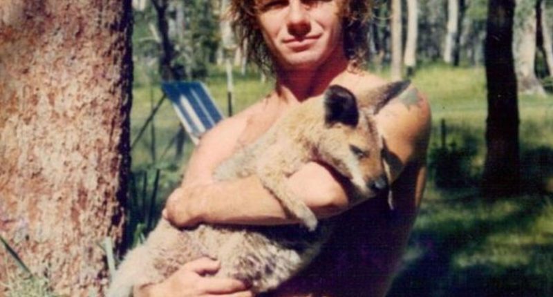 A man holding a kangaroo joey.