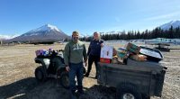 Couple unloading groceries from a utility vehicle in Alaska.