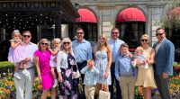 Large family group posing in front of the St. Regis hotel.