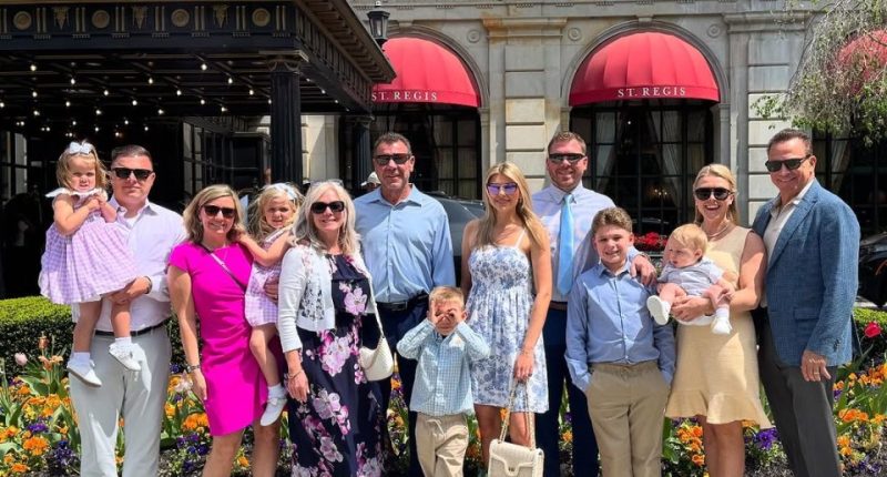 Large family group posing in front of the St. Regis hotel.