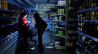 A worker assists a customer with a torch at a supermarket during a power outage which hit large parts of Spain, in Barcelona, Spain April 28, 2025. REUTERS/Nacho Doce TPX IMAGES OF THE DAY