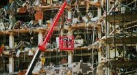 Rescue workers in a lift amidst rubble from a bombed building.