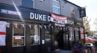 The Duke of Edinburgh pub in Royton, Oldham, decorated with England flags and a Manchester United banner.