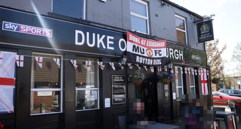 The Duke of Edinburgh pub in Royton, Oldham, decorated with England flags and a Manchester United banner.