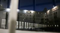 Night view of prison cells through a window.