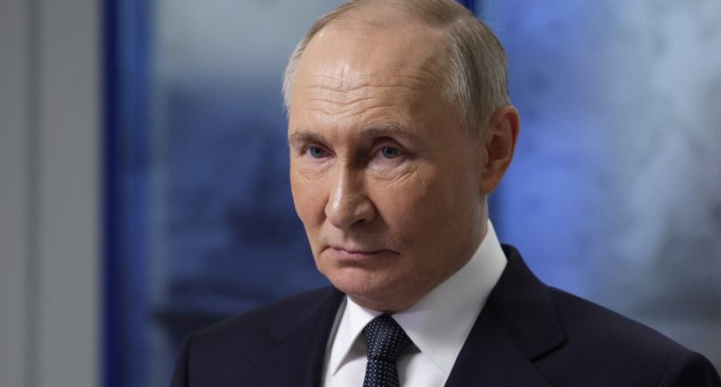 Vladimir Putin in a dark suit and tie.