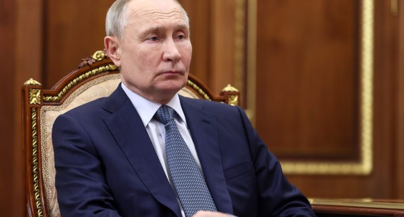 Vladimir Putin seated at a meeting.