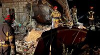 Firefighters battling a fire at a damaged factory.