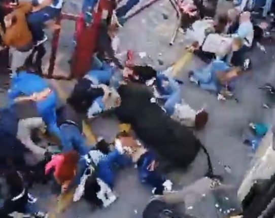 A bull charging through a crowd of people.