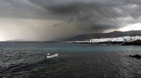 Stormy weather over Lanzarote, Canary Islands; a small boat in the foreground.