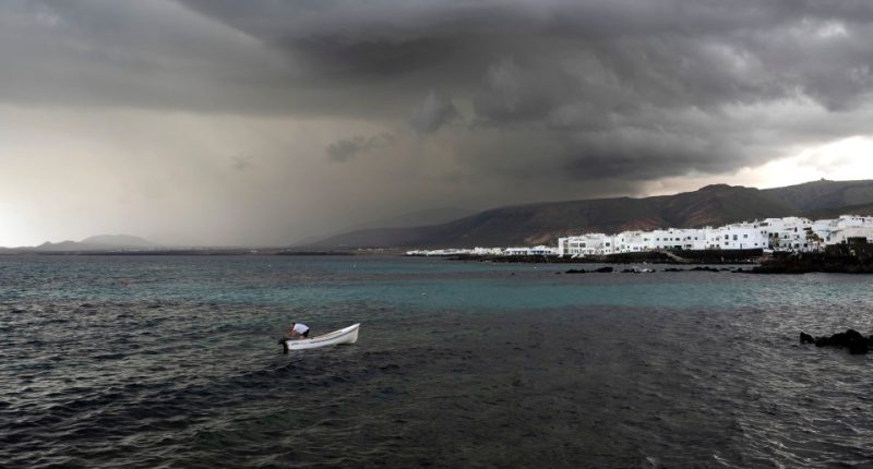 Stormy weather over Lanzarote, Canary Islands; a small boat in the foreground.