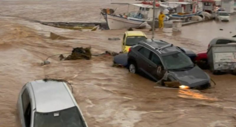 Flooded harbor in Naoussa, Paros, Greece, with several submerged vehicles.