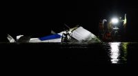Emergency crews at night responding to a plane crash in a river.