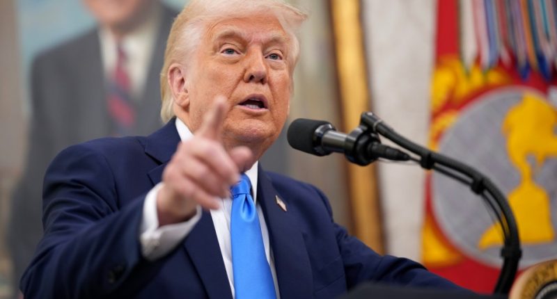 Donald Trump speaking at a microphone.