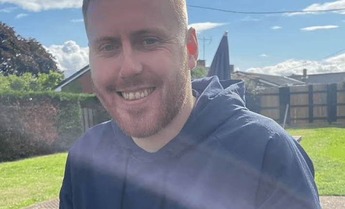 Man smiling outdoors.