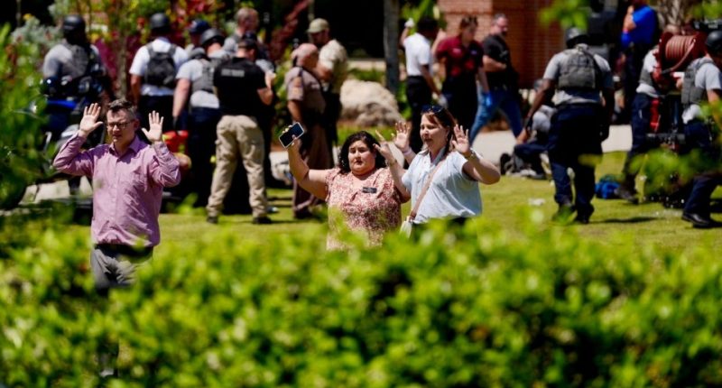 People evacuating a university campus after a mass shooting.