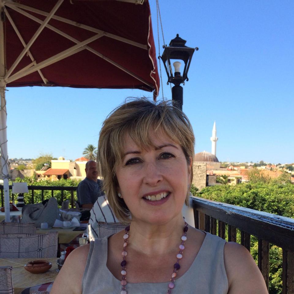 Woman on a patio with a view of a town and a mosque.