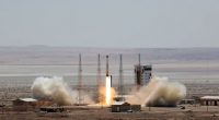 Satellite rocket launching from a desert launchpad.
