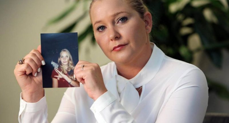 Woman holding a photo of a younger woman.