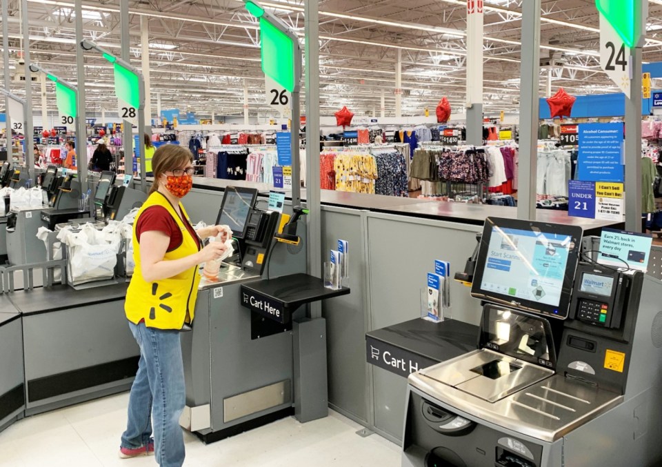 Walmart employee at self-checkout.