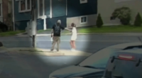 Two people interacting on a street corner.
