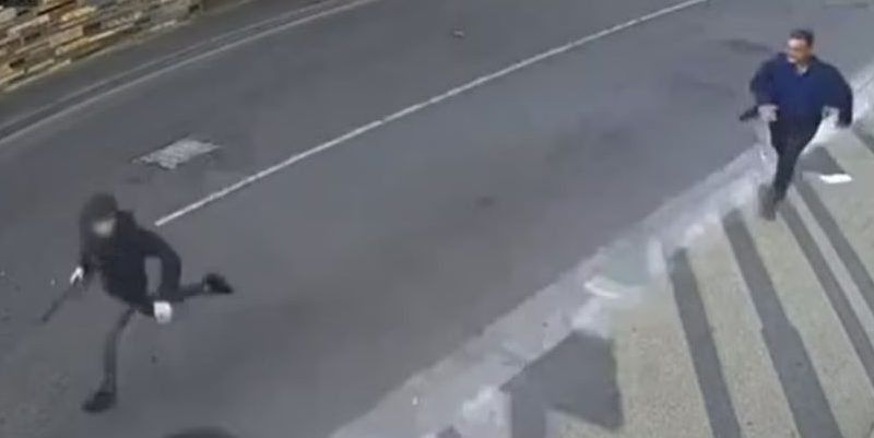 Security camera footage of a man chasing a person.
