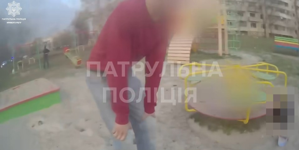 Person bending over near playground equipment.