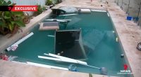 Swimming pool with furniture and trash in it after a party.