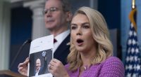 White House press secretary Karoline Leavitt with Treasury Secretary Scott Bessent, back left, shows a picture of Jeff Besos as she responds to a question about Amazon, during a briefing in the James Brady Press Briefing Room at the White House, Tuesday, April 29, 2025, in Washington. (AP Photo/Manuel Balce Ceneta)
