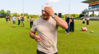 A TV cameraman has been left with a scratched forehead after he was hit in the head by a wayward ball kicked by Opposition Leader Peter Dutton at a photo-op in Darwin.