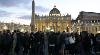 VATICAN CITY, VATICAN - APRIL 24:  Faithful wait in line in St. Peter's Square to enter the Basilica to pay homage to the body of Pope Francis on April 24, 2025 in Vatican City, Vatican. On the fourth day since his death was announced by the Vatican, the body of  Pope Francis lies in state in a simple wooden coffin at the Basilica St Peter.  His funeral will be held on Saturday, 26th April 2025. (Photo by Marco Di Lauro/Getty Images)