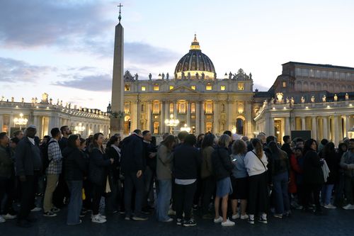 VATICAN CITY, VATICAN - APRIL 24:  Faithful wait in line in St. Peter's Square to enter the Basilica to pay homage to the body of Pope Francis on April 24, 2025 in Vatican City, Vatican. On the fourth day since his death was announced by the Vatican, the body of  Pope Francis lies in state in a simple wooden coffin at the Basilica St Peter.  His funeral will be held on Saturday, 26th April 2025. (Photo by Marco Di Lauro/Getty Images)
