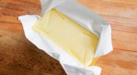 A block of butter on a cutting board.