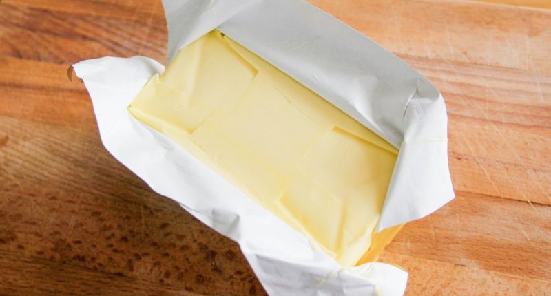 A block of butter on a cutting board.