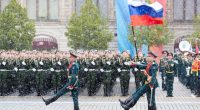 Russian honor guard soldiers marching with the national flag during a Victory Day military parade in Moscow.