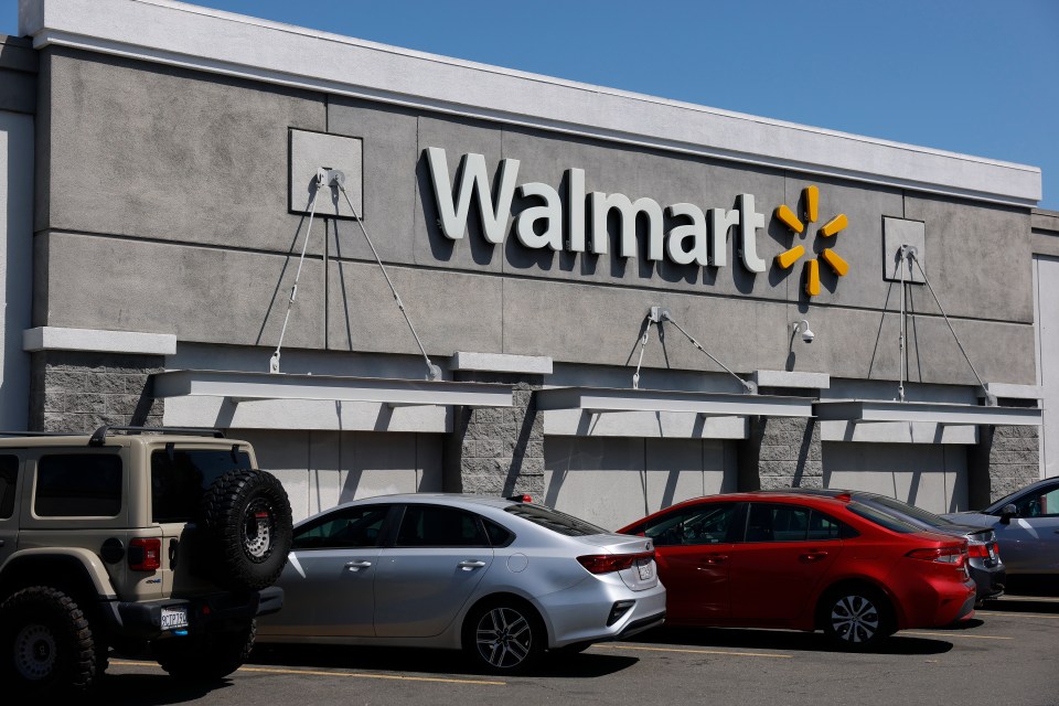 Walmart store exterior with cars parked in front.