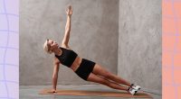 fit blonde woman doing a side plank exercise in front of grey backdrop