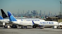 United Airlines planes at an airport with a city skyline in the background.