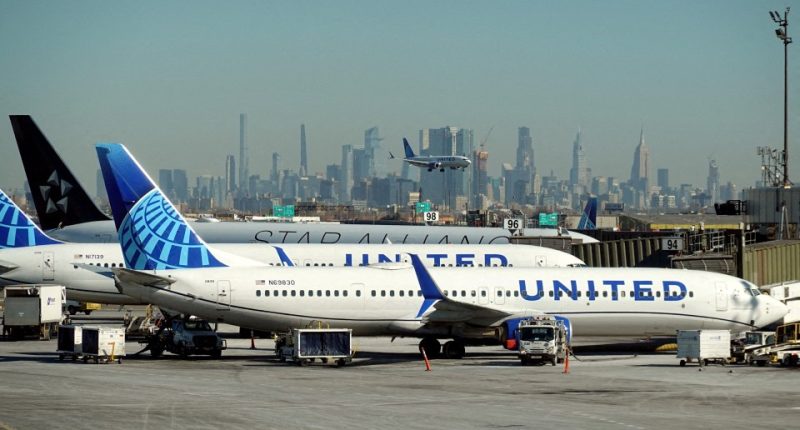 United Airlines planes at an airport with a city skyline in the background.