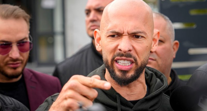 Andrew Tate speaking to the media outside a police station.