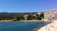 Portals Nous, Majorca: a beach with turquoise water, boats, and buildings on a hillside.
