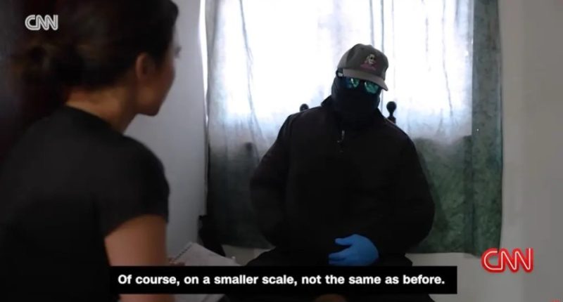 A masked Sinaloa cartel member being interviewed by CNN.